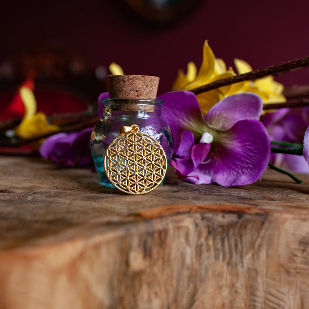frasco con colgante flor de la vida dorado