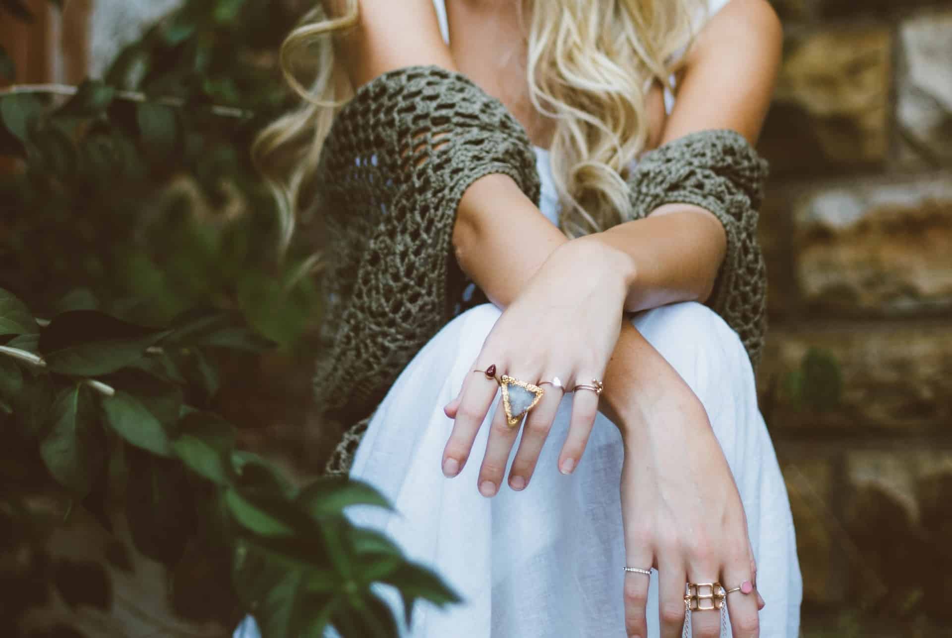 blog reiki mujer sentada con los brazos cruzados y muchos anillos